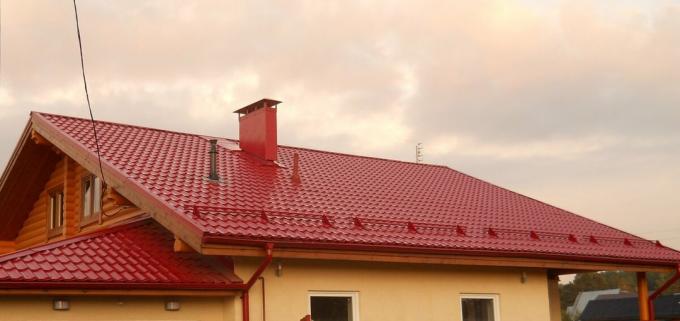Ein Dach mit Dacheindeckungen - Metall in der fertigen Form. Bild mit Yandeks.Kartinki Service.